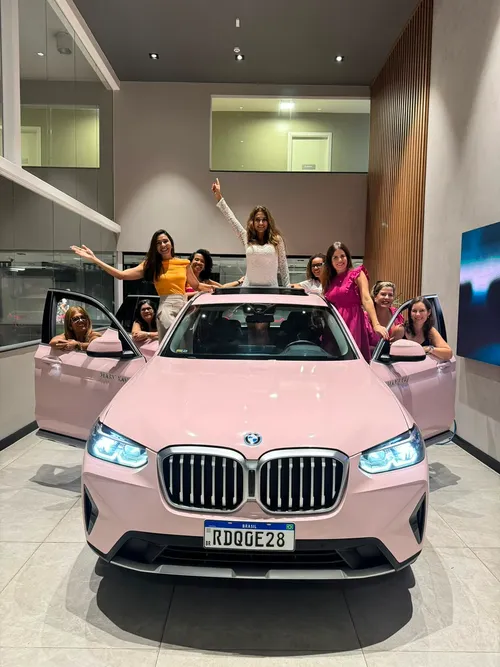 Grupo de consultoras Mary Kay comemorando ao redor de um BMW rosa